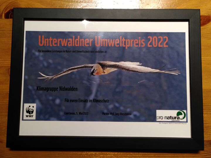 Urkunde Unterwaldner Umweltpreis 2022 Klimagruppe Nidwalden für den Einsatz im Klimaschutz. Im Hintergrund ist ein Bartgeier im Flug zu sehen.